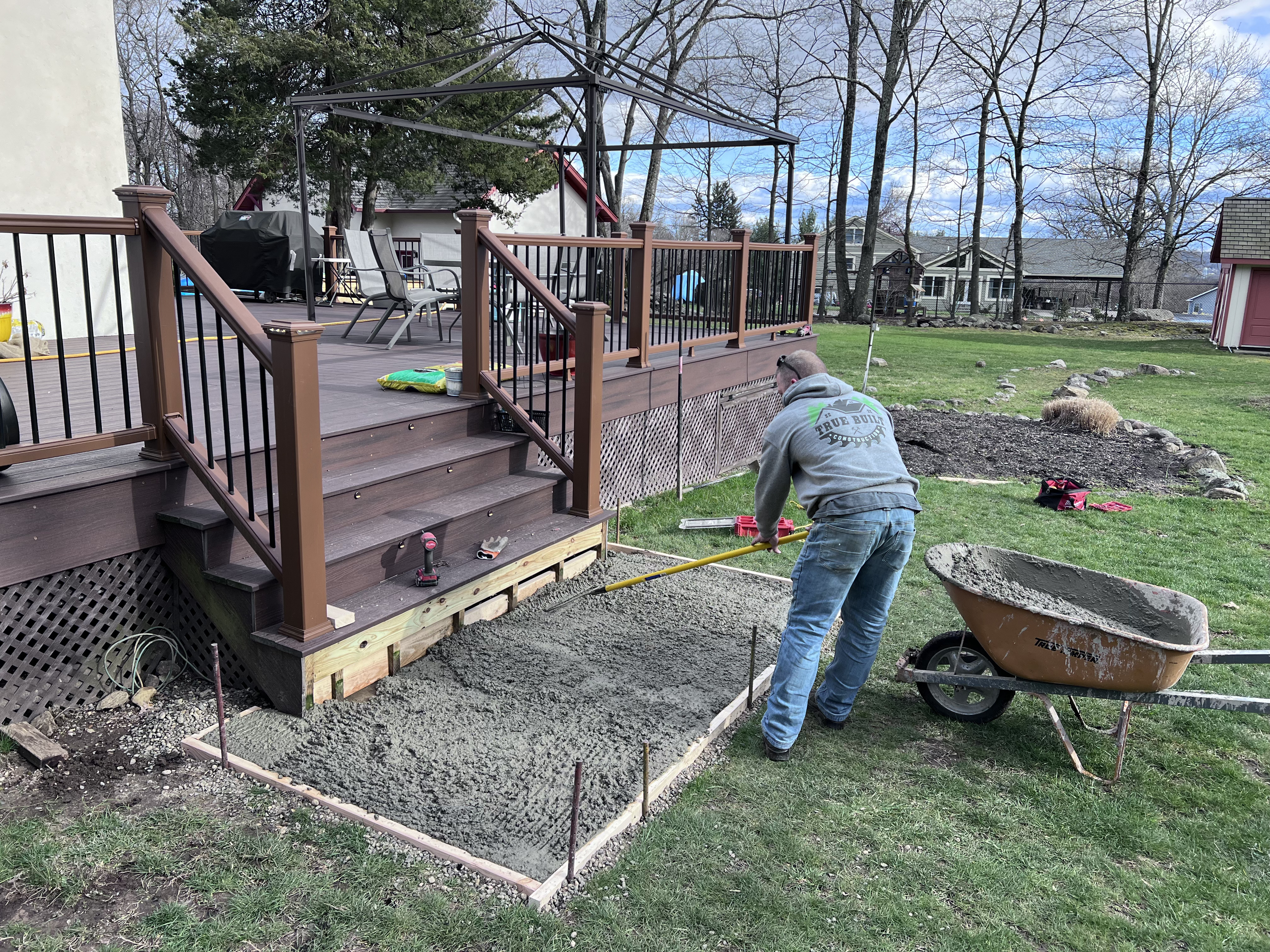 Corey Wray of True Built Construction personally grading the ground in preparation for a new deck and patio