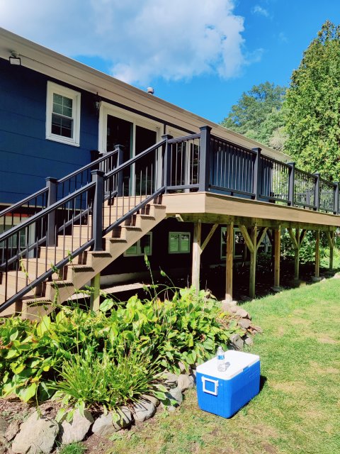 An expansive, newly remodeled deck by True Built Construction boasts robust, espresso-hued decking that seamlessly extends the living space into the outdoors, complemented by durable railings that promise safety without sacrificing style