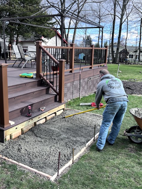 Corey Wray of True Built Construction personally grading the ground in preparation for a new deck and patio, ensuring a solid foundation for the high-quality outdoor space