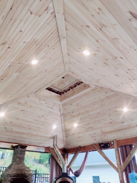 True Built Construction's recent project, an open-air wooden gazebo with a stunning vaulted ceiling, showcasing natural pine boards and recessed lighting. The craftsmanship accentuates the inviting ambiance of this outdoor entertainment area
